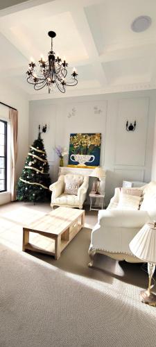 a living room with a christmas tree and a chandelier at A private room with lounge room in Unanderra