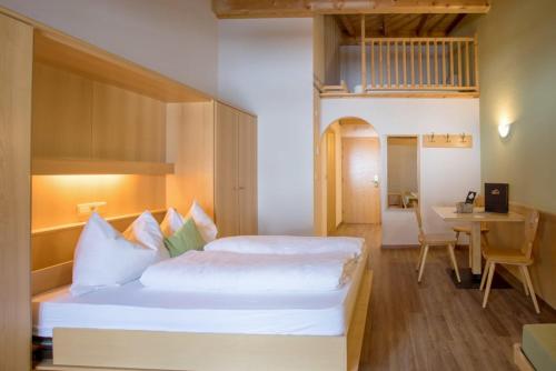 a bedroom with a large white bed and a desk at Mountain Living Apartments in San Valentino alla Muta