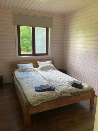 a bedroom with a bed with two towels on it at Aru talu külalistemaja in Iilaste