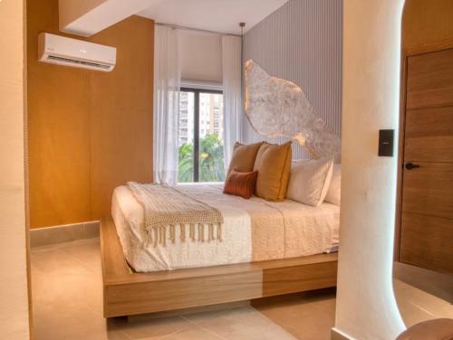 a bedroom with a bed and a window at Torre Palmas Marcel in Ensanche Quisqueya