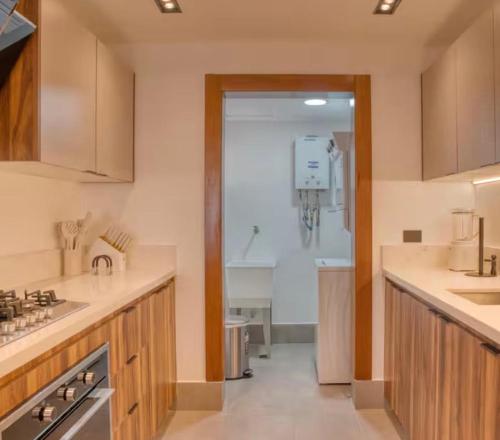 a large kitchen with a sink and a shower at Torre Palmas Marcel in Ensanche Quisqueya