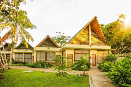 a house with a palm tree in front of it at Decameron Decalodge Ticuna in Leticia