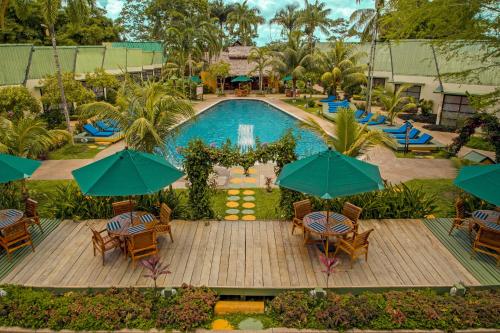 an aerial view of a pool with tables and umbrellas at Decameron Decalodge Ticuna in Leticia