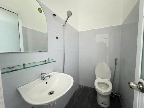 a white bathroom with a sink and a toilet at QN Home in Quy Nhon