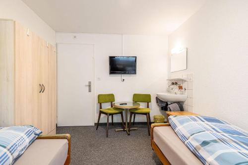 a bedroom with a bed and a table and chairs at Hotel Haus am Wald in Arosa