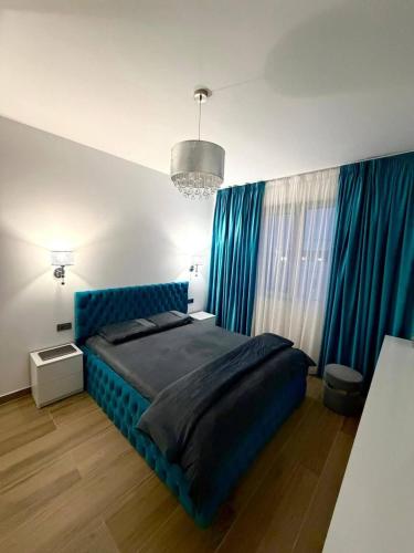 a bedroom with a blue bed and blue curtains at Adinna Residence in Giroc