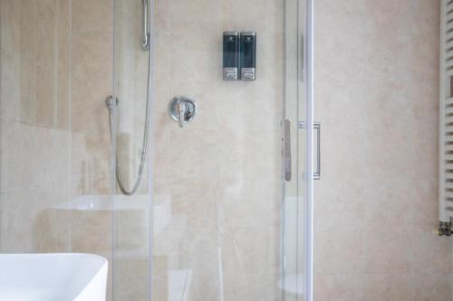 a bathroom with a shower with a glass door at Humanitas - Leo Brothers - Leopardi 1 in Basiglio