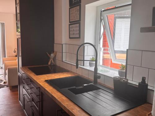 a kitchen with a black sink and a window at Hesketh Hideaway 1 in Marshside