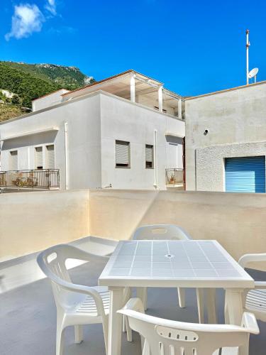 a white table and white chairs on a balcony at L'angolo blu in Marettimo