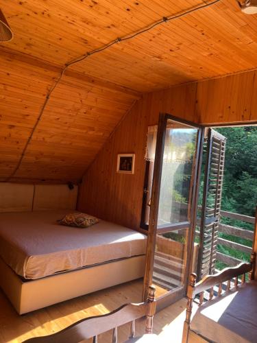 a bed in a wooden room with a window at Weekendica in Kopaonik