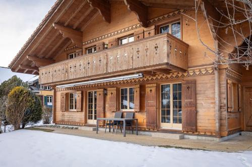 a wooden house with a table in front of it at Apartment Chalet Condor - Aare Jungfrau AG in Grindelwald