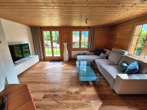 a living room with a couch and a table at Apartment Chalet Condor - Aare Jungfrau AG in Grindelwald
