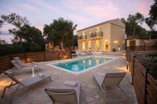 a swimming pool with chairs and a house at Villa Praxithea in Lákka