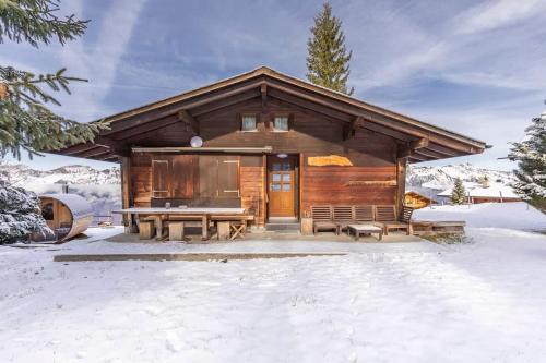 Eine Blockhütte mit Picknicktisch im Schnee in der Unterkunft Sara in Axalp