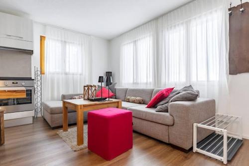 a living room with a couch and a table with a red stool at Schwabhorn in Axalp