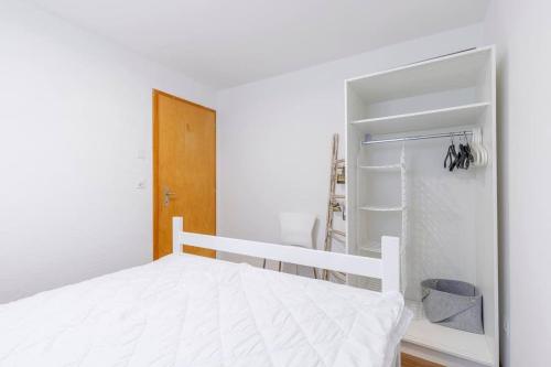 a white bedroom with a bed and a closet at Schwabhorn in Axalp