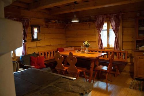 a dining room with a wooden table and chairs at Zbojnícke Chalúpky in Čavoj