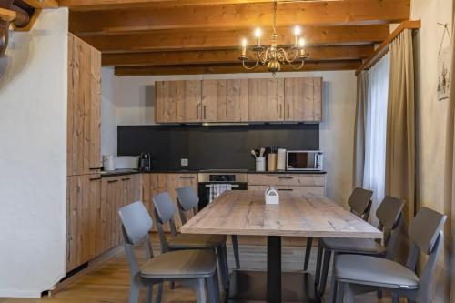 a kitchen with a large wooden table and chairs at Apartment Eiger - Aare Jungfrau AG in Grindelwald