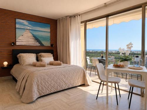 a bedroom with a bed and a table with chairs at La Marina Cannes Suites in Mandelieu-La Napoule