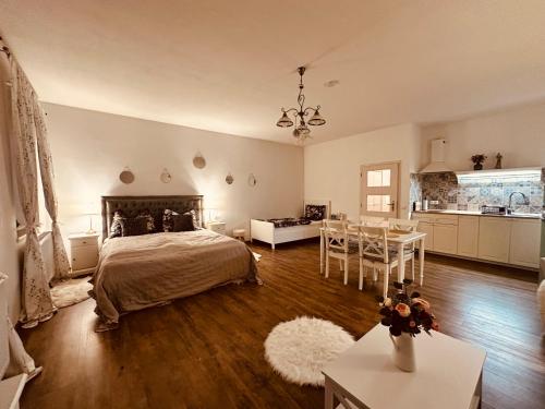 a bedroom with a bed and a table and a kitchen at Farma P&P Apartmány in Vrchovany