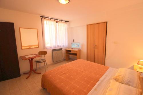 a bedroom with a bed and a desk with a computer at IDA St2, FEW STEPS FROM THE BEACH in Novigrad Istria
