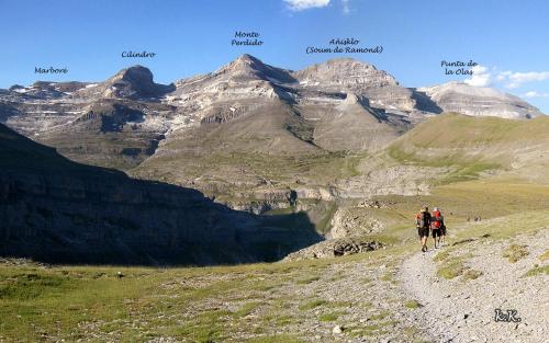a group of people walking down a mountain trail at Pinarillos in Sarvisé