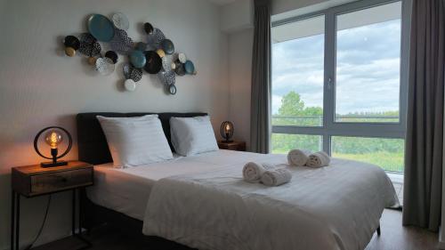 a bedroom with a bed with towels on it at Residentie De Zeester | 4 Pers. De Zeester in Scherpenisse