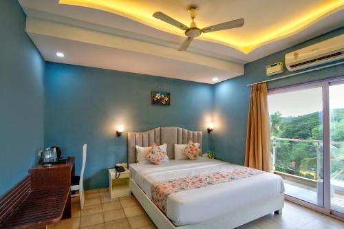 a bedroom with a bed with a blue wall at De Alcazar Calangute in Calangute