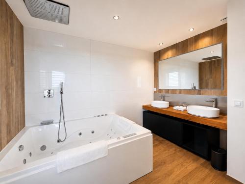 a white bathroom with a tub and two sinks at VILLA MIAMI in Les Issambres
