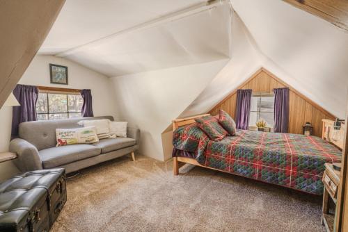 a bedroom with a bed and a couch in a attic at Gonzalez Cabin in Running Springs