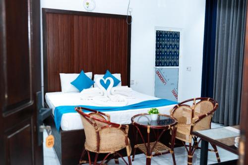 a hotel room with a bed with a table and chairs at Aathi Resort in Trincomalee