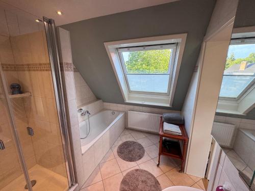 a bathroom with a shower and a tub and a window at Kramerhof in Groß Fredenbeck