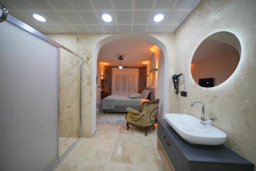 a bathroom with a sink and a shower and a bed at Diamond Village Ortahisar in Ürgüp