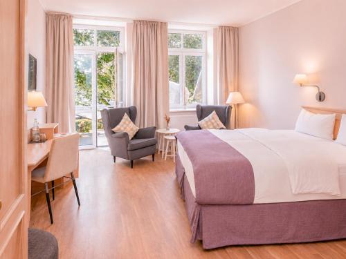a hotel room with a bed and a desk and chairs at BE BIO Hotel be active - Nähe historischer Hafen in Tönning