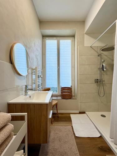 a bathroom with a sink and a mirror and a shower at Maison 85 m2 deux chambres in Cazères