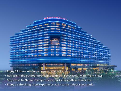 a large blue building with a sign on top at Sheraton Zhuhai Hotel in Zhuhai