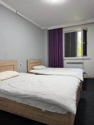 two twin beds in a bedroom with a window at 名宿 395 Hostel in Bishkek