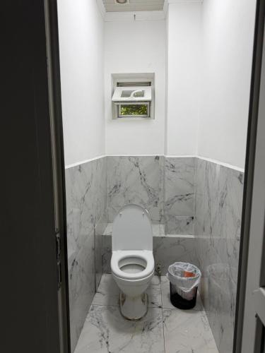 a bathroom with a toilet and a trash can at 名宿 395 Hostel in Bishkek