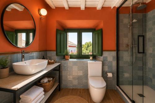 an orange bathroom with a sink and a shower at Molino de Búlar - 1920 Olive Oil Mill Heritage in Piñar