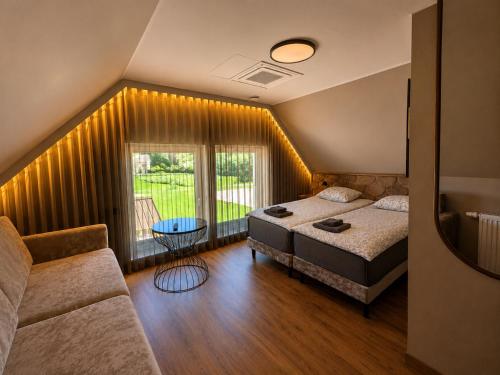 a bedroom with a bed and a couch and a window at Reiu Holiday Centre in Pärnu