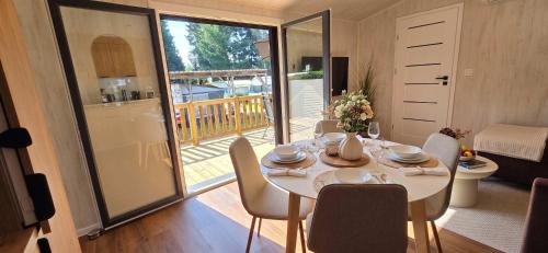 ein Esszimmer mit Tisch und Stühlen und einem Balkon in der Unterkunft Tinyhouse SeeZeit in Lohmen