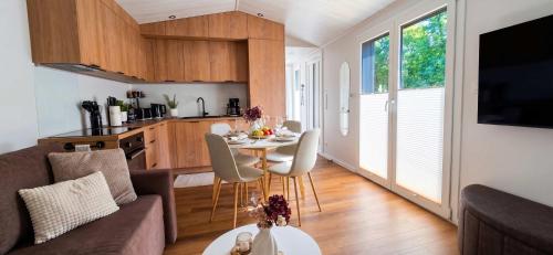 eine Küche und ein Wohnzimmer mit Tisch und Stühlen in der Unterkunft Tinyhouse SeeZeit in Lohmen