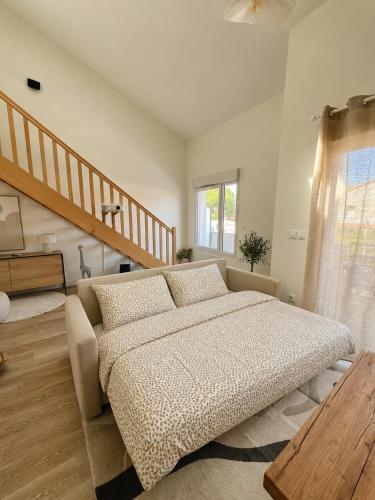a bedroom with a large bed and a staircase at Le Vigne - Terrasse privée in Aytré