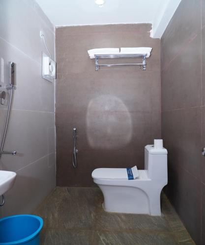 a bathroom with a toilet and a sink at Hotel G Grand Inn in Thanjāvūr