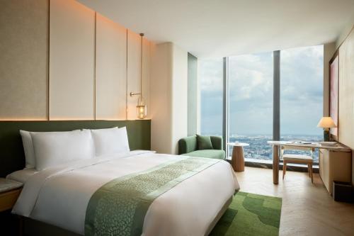 a hotel room with a bed and a large window at Steigenberger Phnom Penh in Phnom Penh