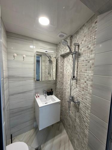 a bathroom with a sink and a shower at Little Studio Prespa Best Location in Varna City