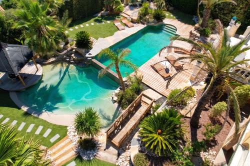 an overhead view of a swimming pool with palm trees at Villa Halo Lagoon Pool & Exclusive seaside getaway in Cap d'Agde