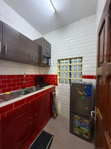 a kitchen with a sink and a refrigerator at Chic Shop House in Abomey-Calavi