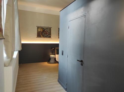 a room with a door leading to a room with a toilet at Alte Schule Gästehaus - Klassenzimmer Loft in Bitburg