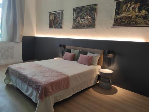 a bedroom with a large bed with pink pillows at Alte Schule Gästehaus - Klassenzimmer Loft in Bitburg